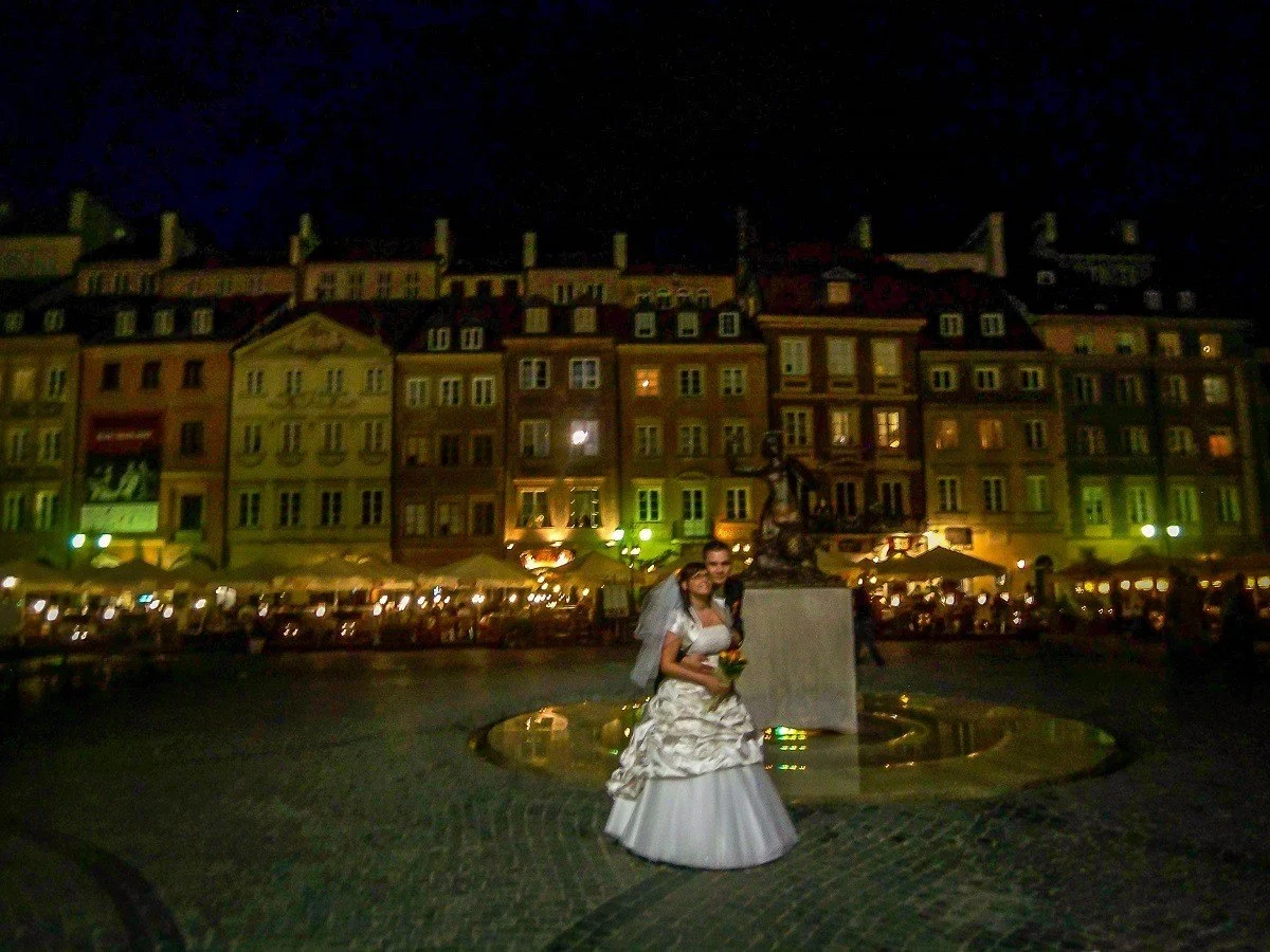 A couple having wedding photos taken in Warsaw's Old Town at night