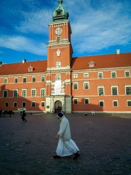 A nun walking in front of the Royal Castle in Warsaw, Poland