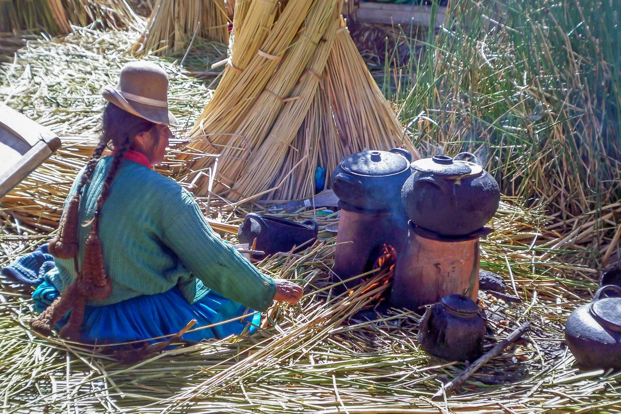 A women tending a cooking fire on the Uros Islands in Peru