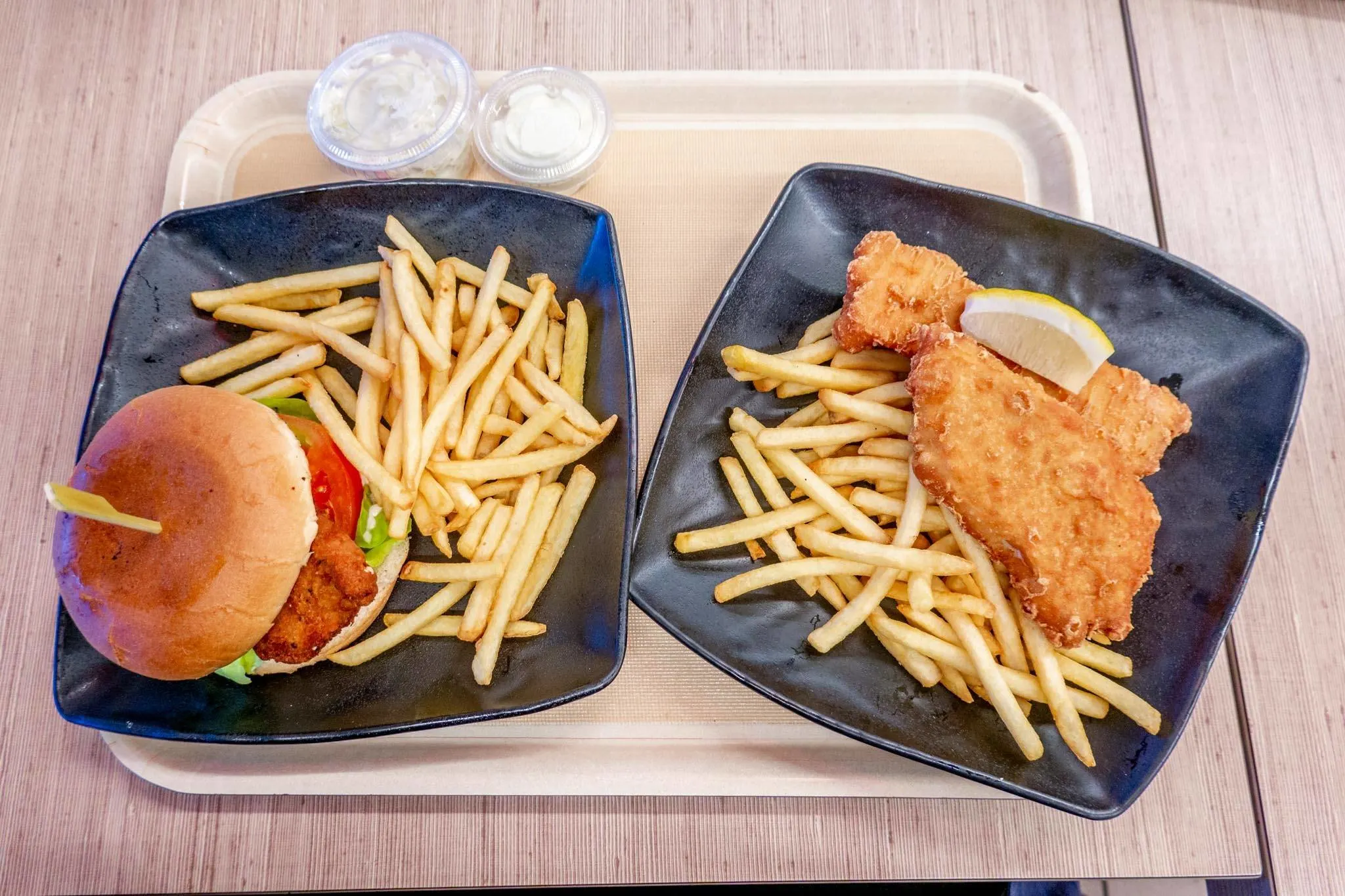 Plates of fish and chips and also a plate with a chicken sandwich