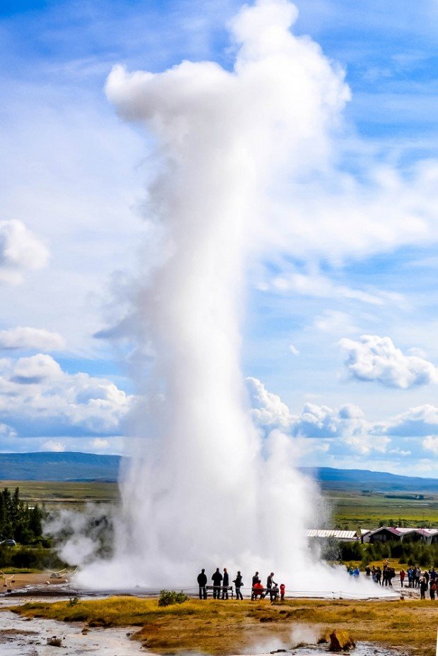 Strokkur geyser erupting with people in front