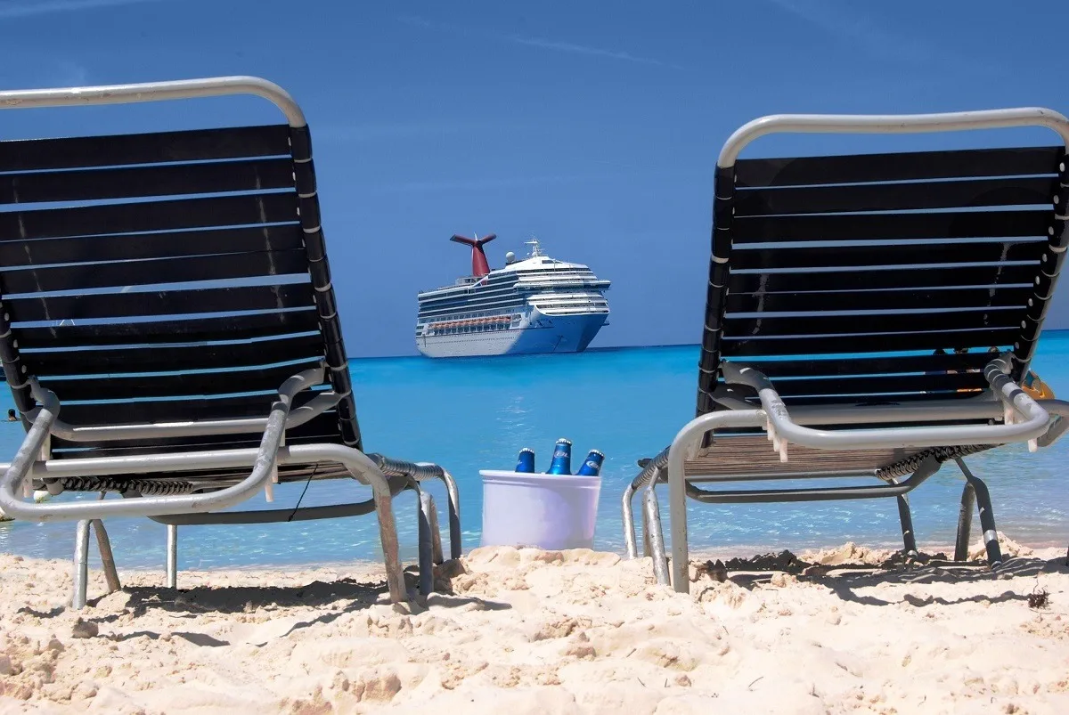 Two sun loungers and a bucket of beer looking out at a cruise ship