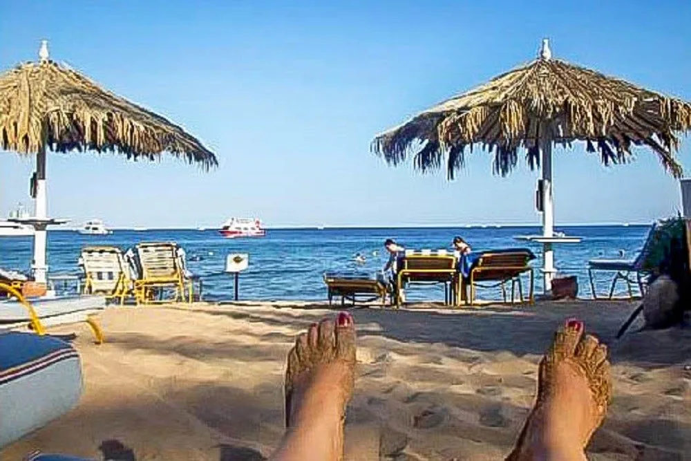 Feet hanging out on the beach with loungers and umbrellas in Sharm el Sheikh Egypt