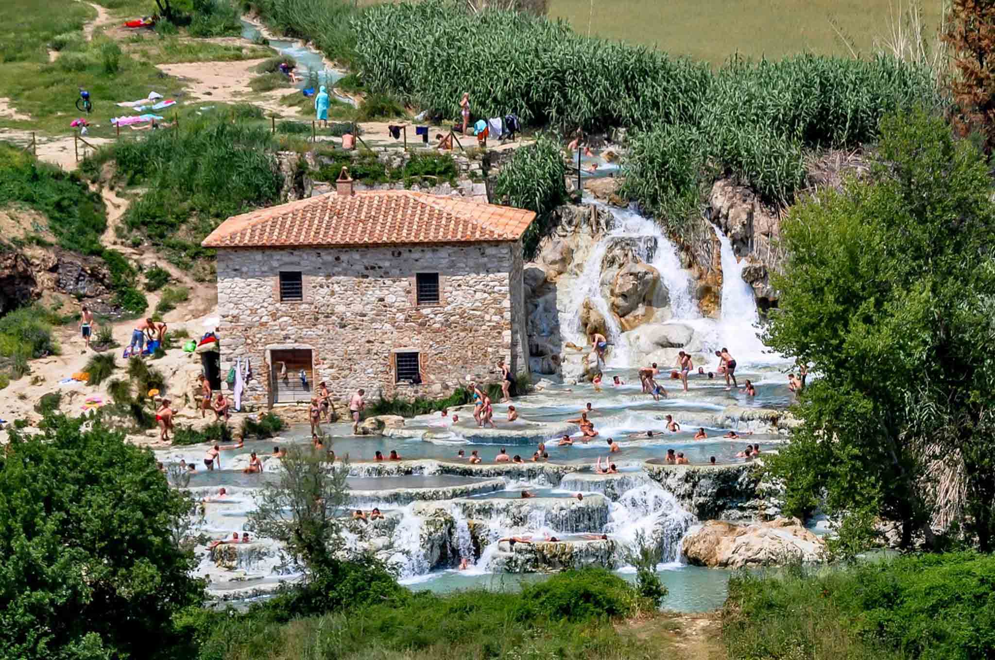 People at a natural hot springs complex with cascading pools