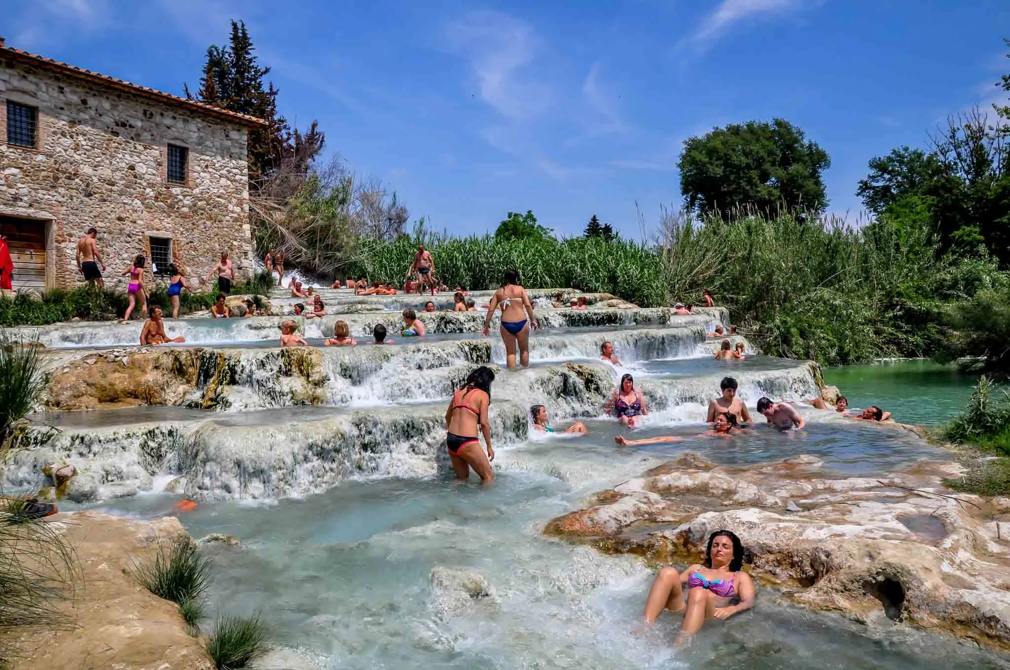 People relaxing in natural cascading pools