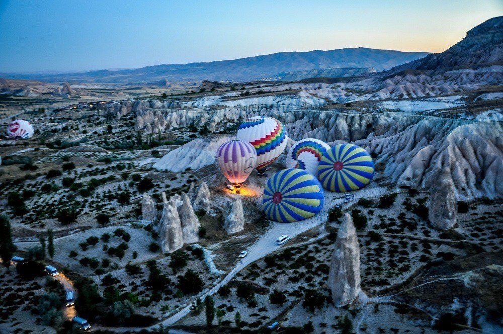 Hot air balloons inflating amid rock formations
