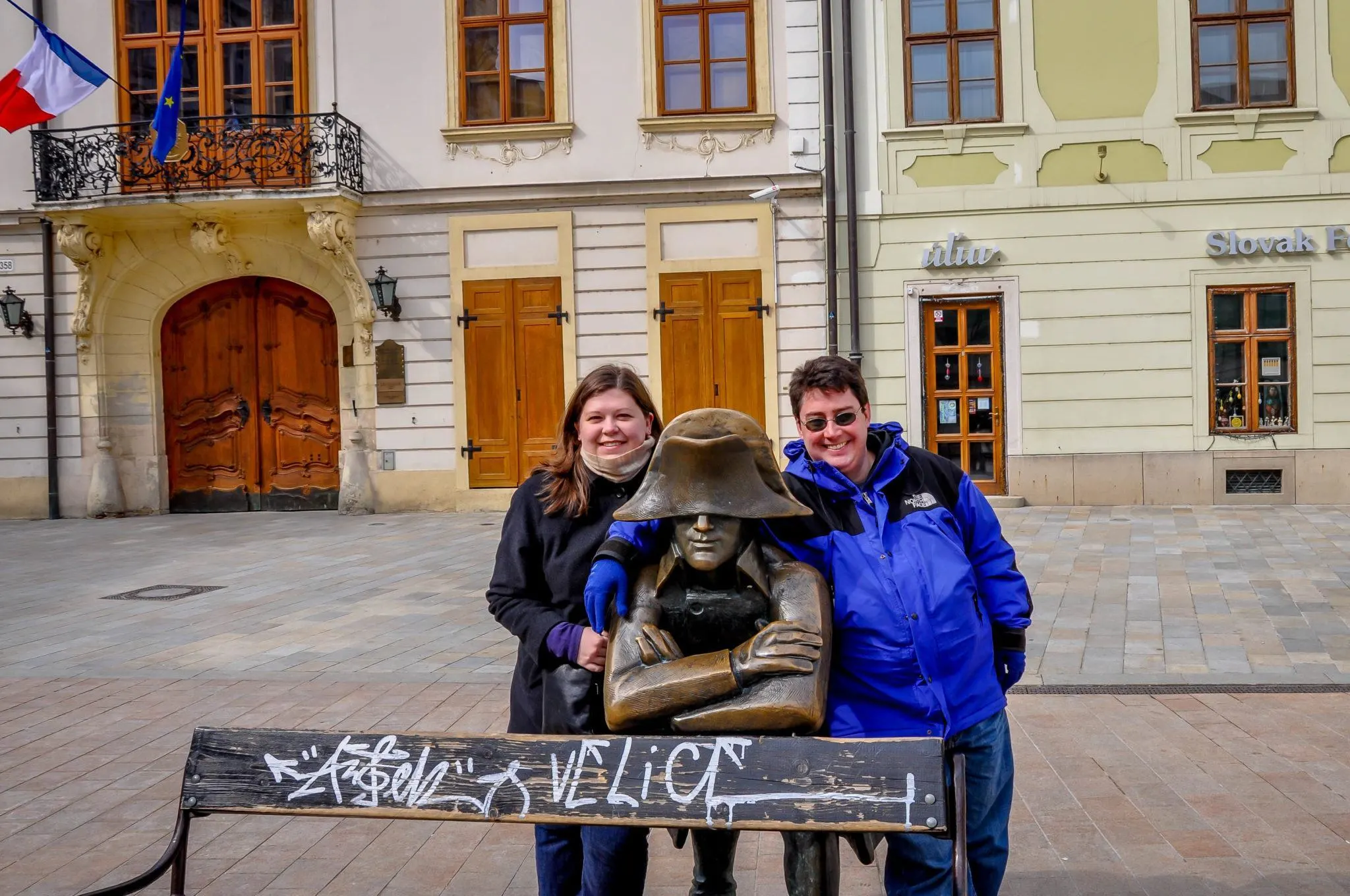 Two people posing with a statue