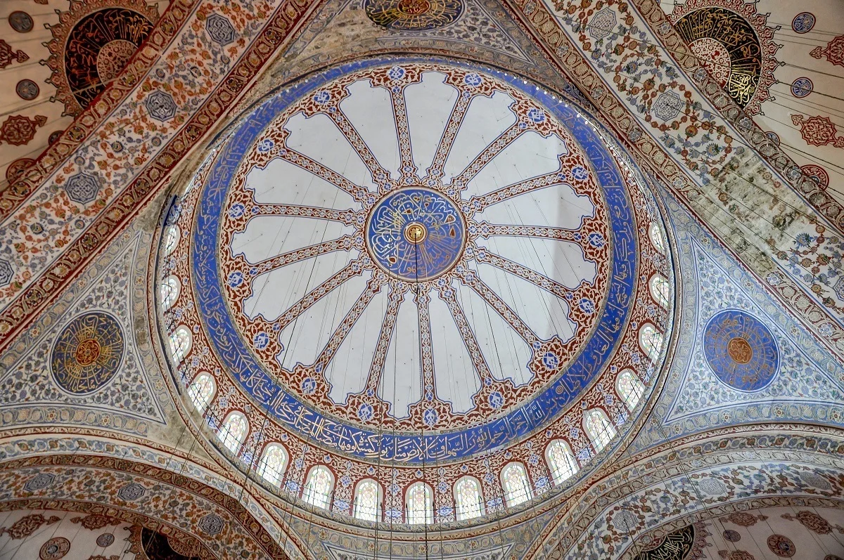 The ornate painted ceiling of the Blue Mosque, one of the top places to see in Istanbul