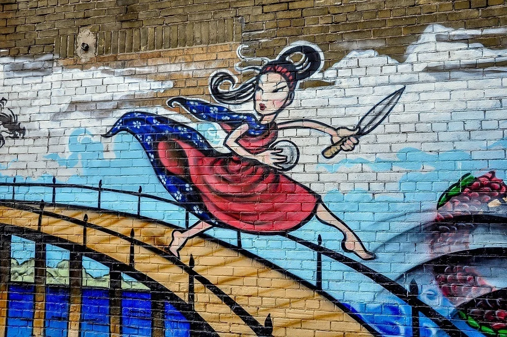 Mural of girl with sword crossing a bridge in Chinatown