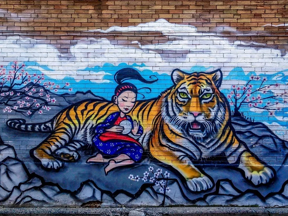 Street art in Chinatown of a girl and a tiger