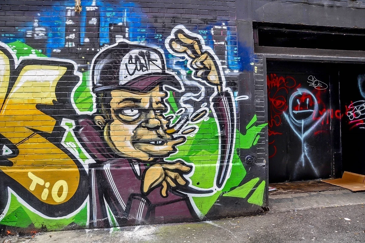 Cartoon mural in alley of man smoking