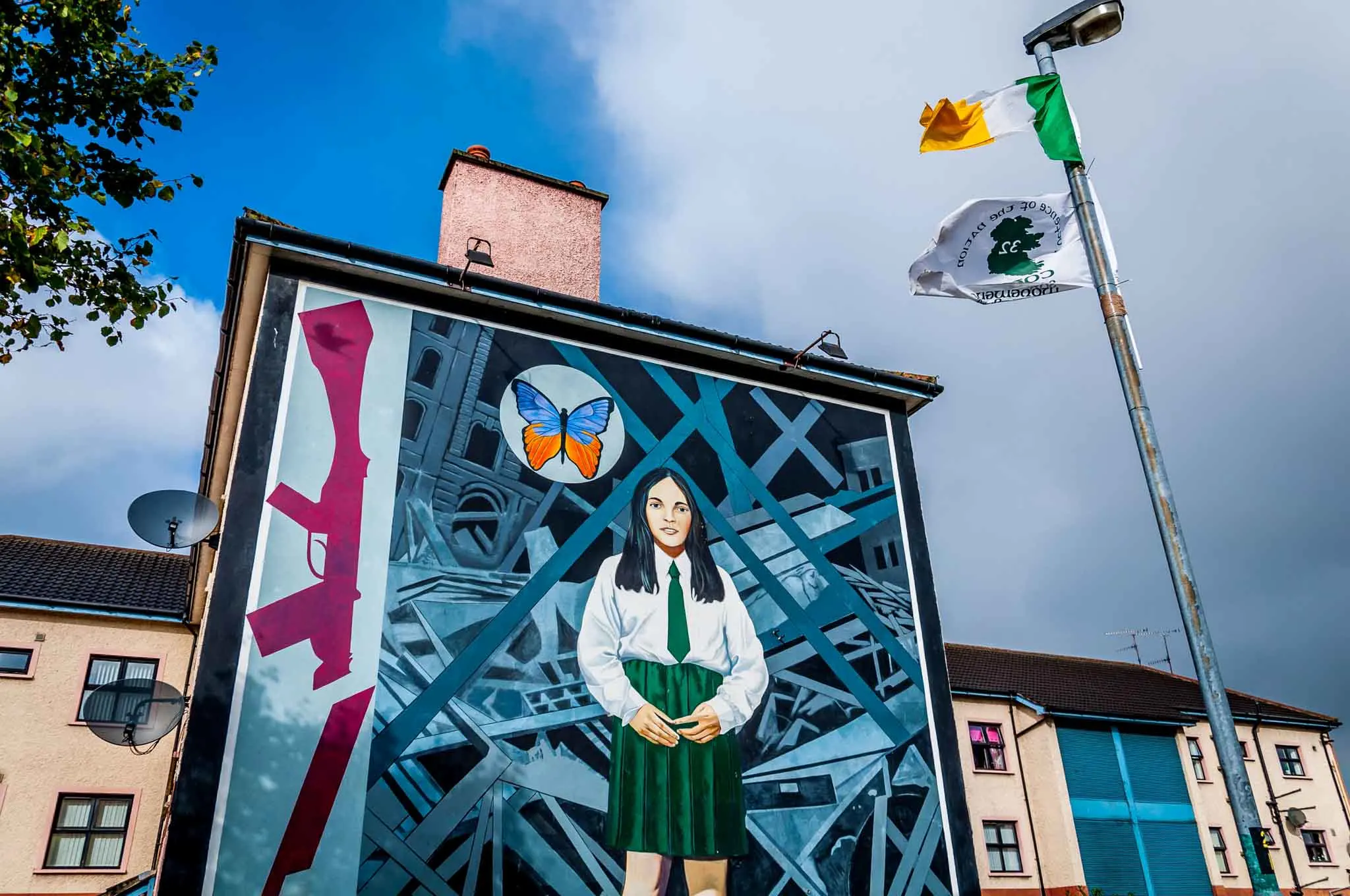 End of Innocence mural featuring girl in a school uniform alongside a broken rifle