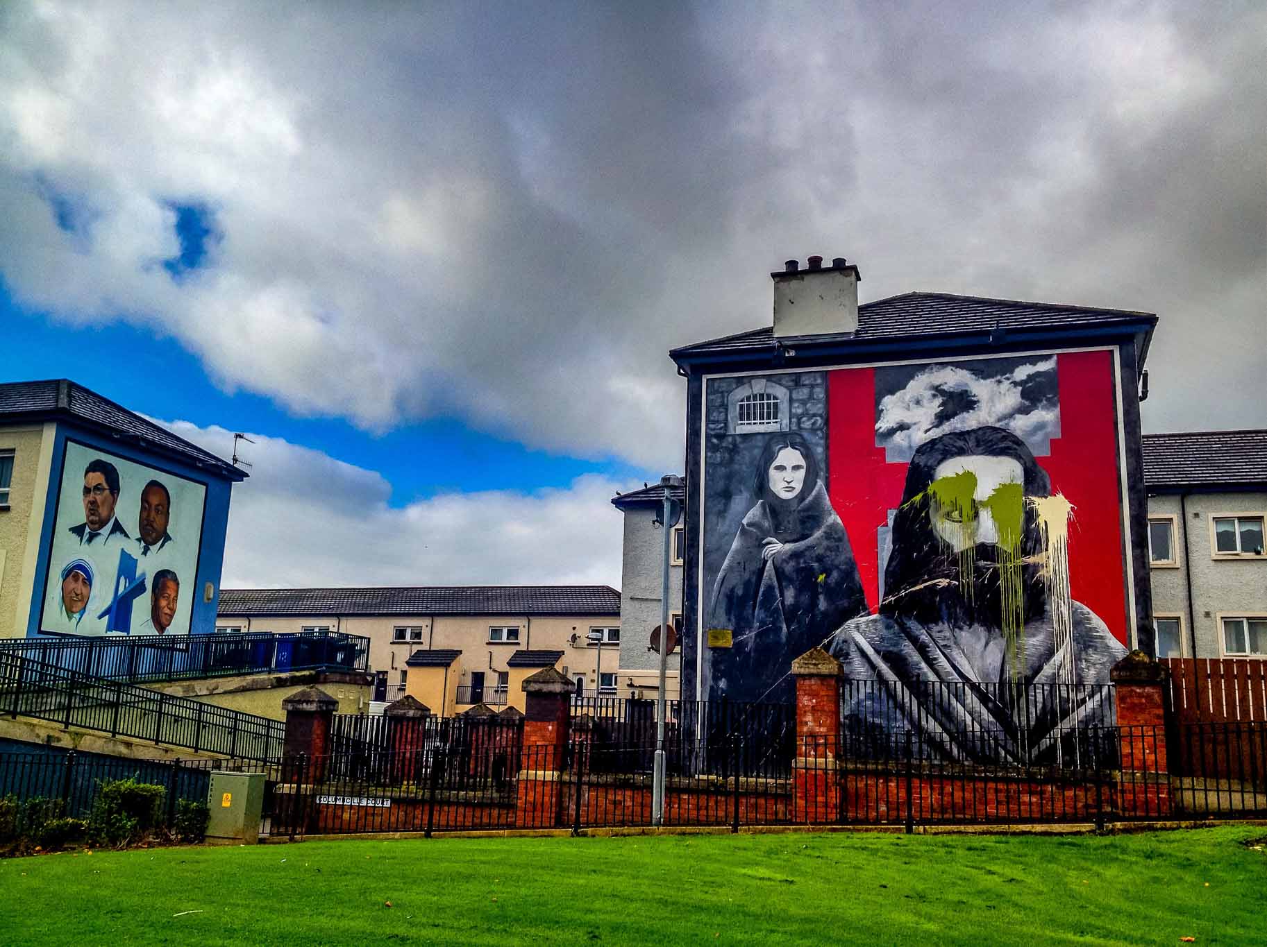 Two of the IRA murals in Derry -- The Hungers Strikers mural with vandalism and the John Hume mural