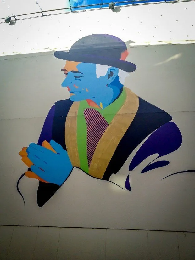 Multi-colored street art of man in a bowler hat
