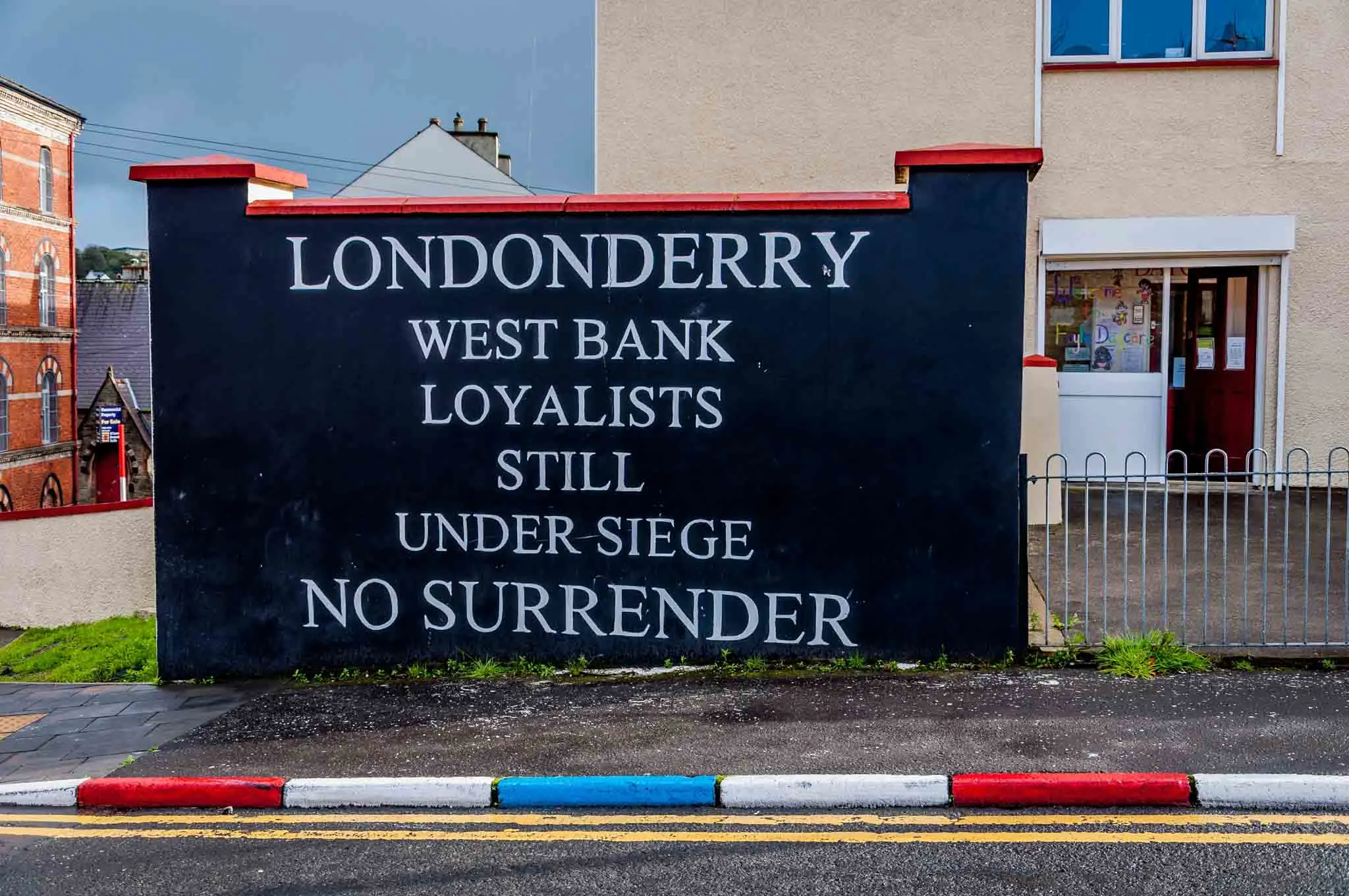 Mural reading:  Londonderry West Bank Loyalists Still Under Siege: No Surrender