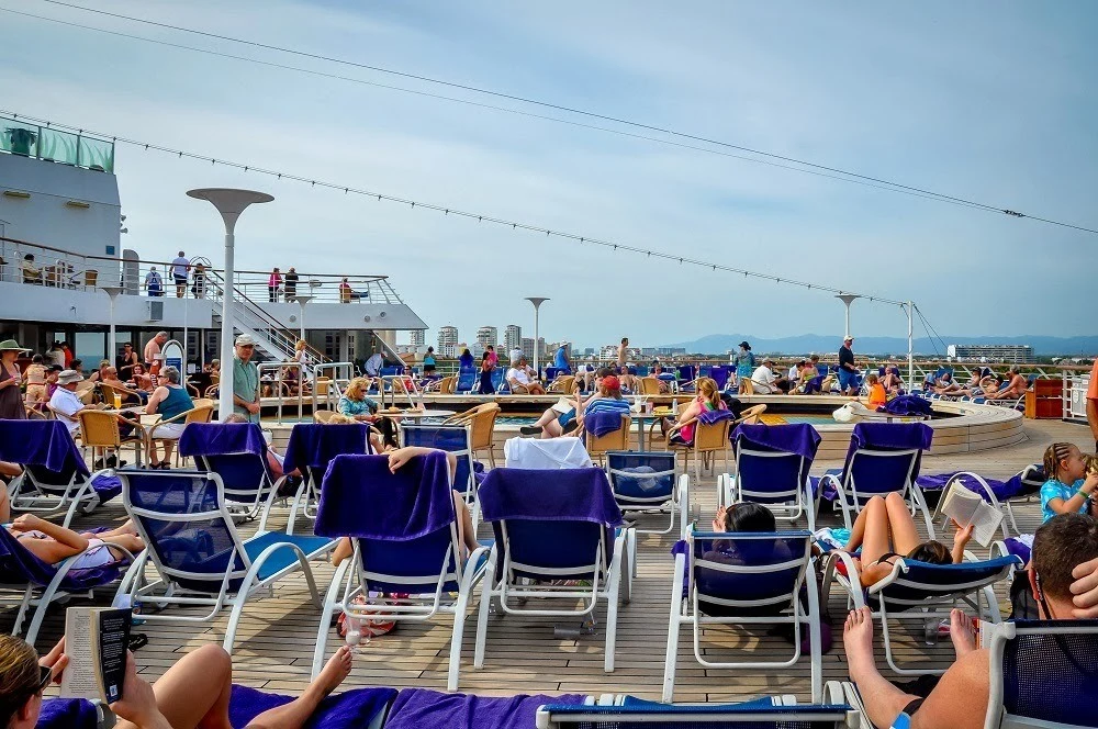 Lounge chairs on a cruise ship around the swimming pool