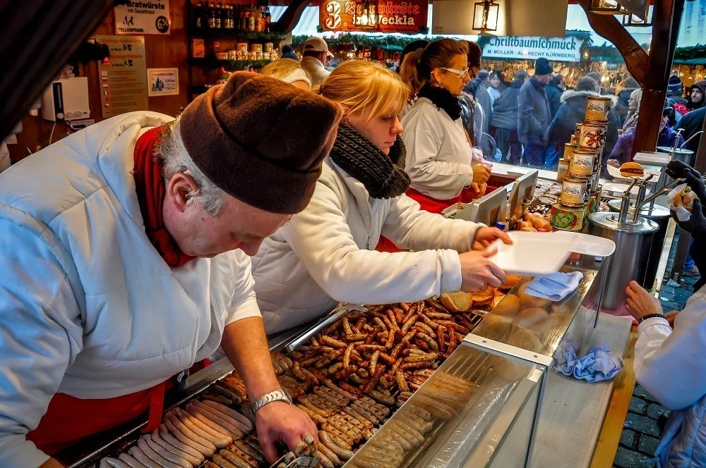 People serving sausage at the German Christmas markets
