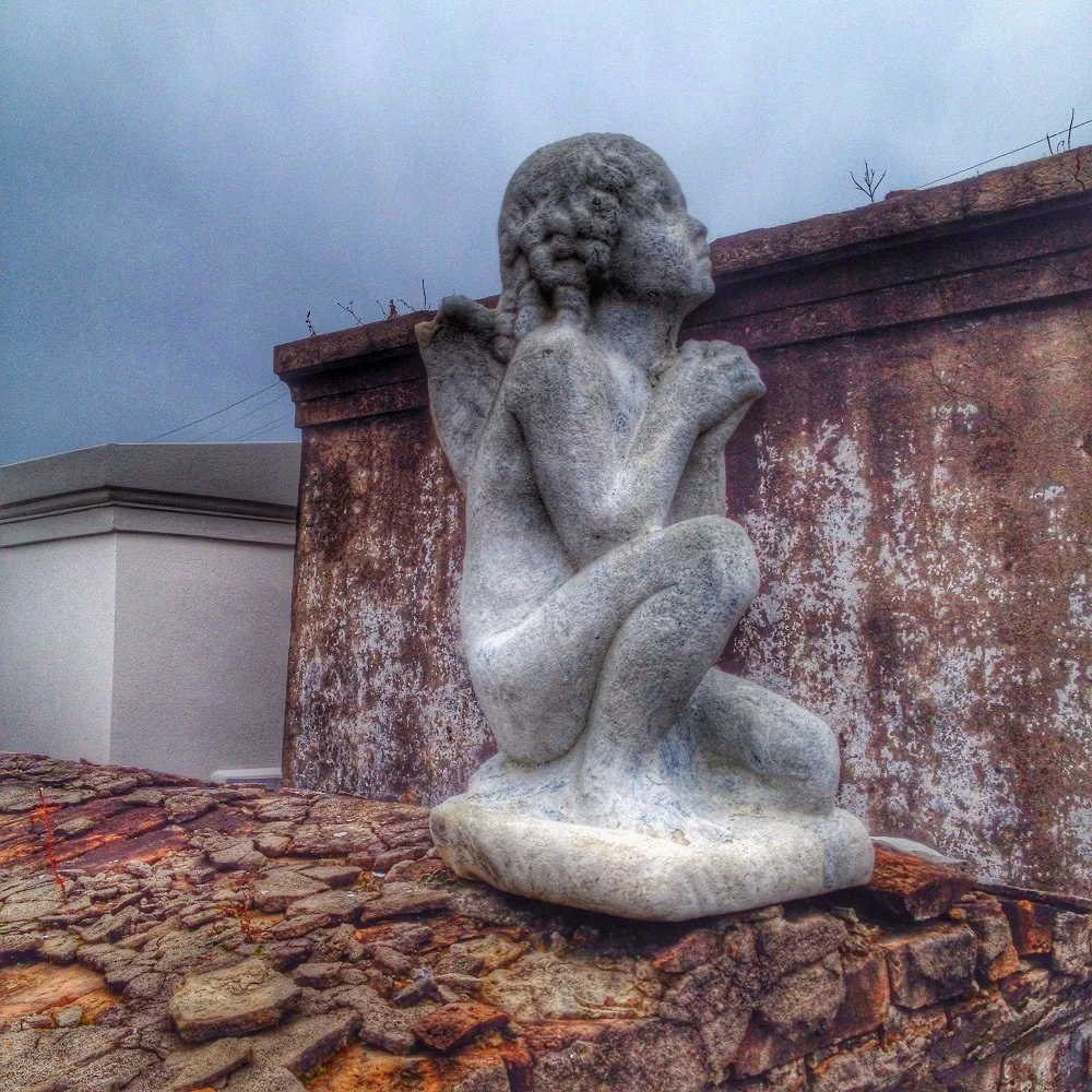 A concrete cherub on a tomb in New Orleans St. Louis Cemetery No. 1