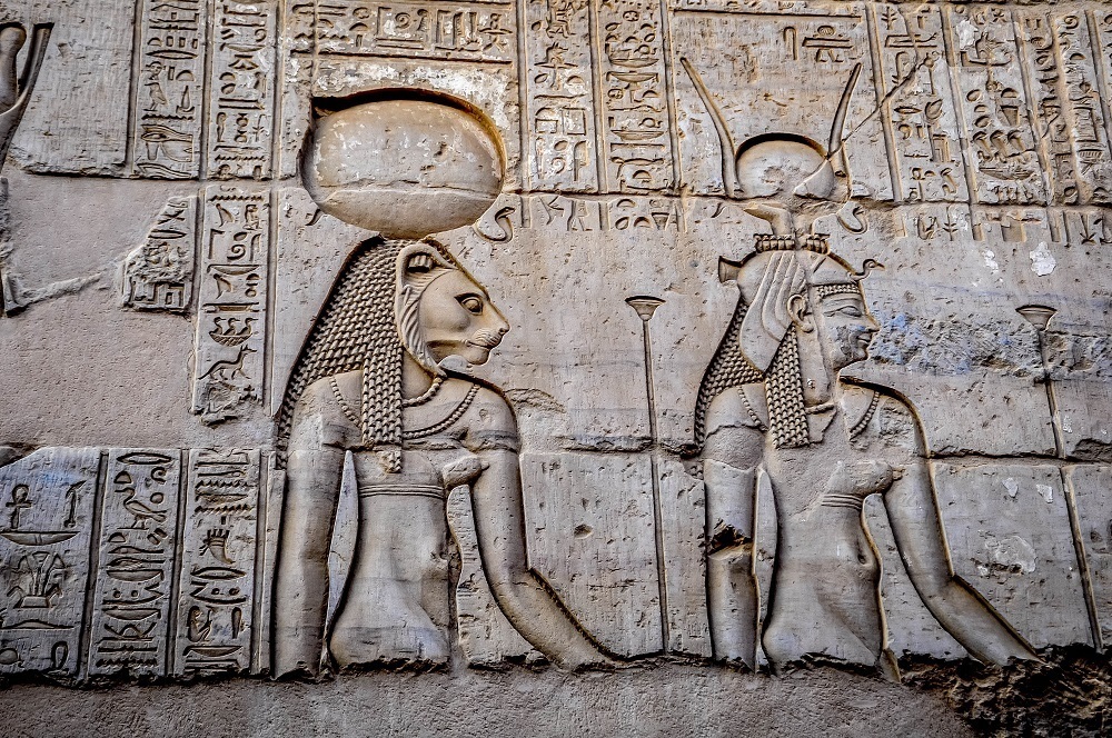 Close up of two carved reliefs of Egyptian gods