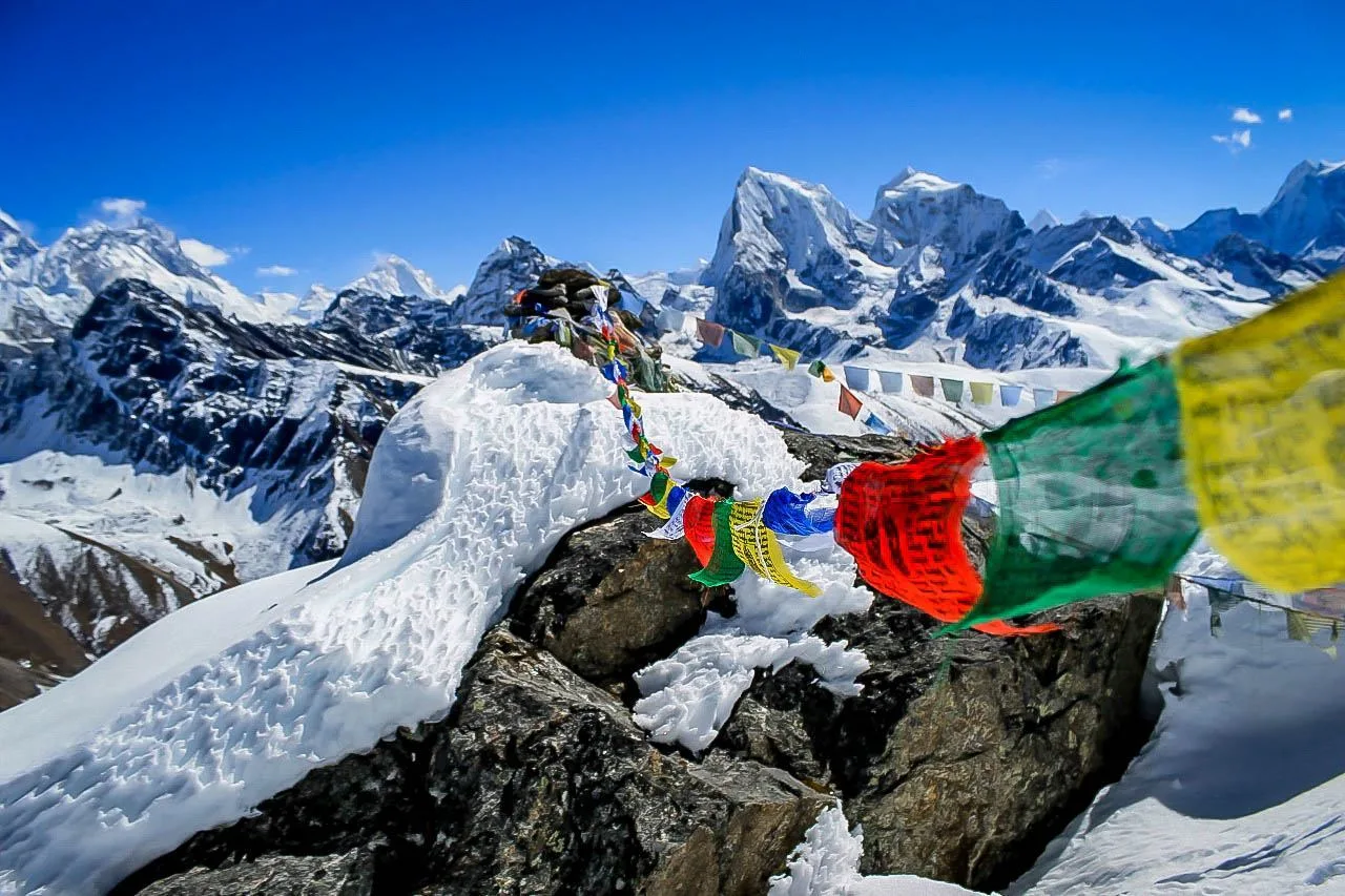 Nepalese prayer flags high in the snow covered Himalayas