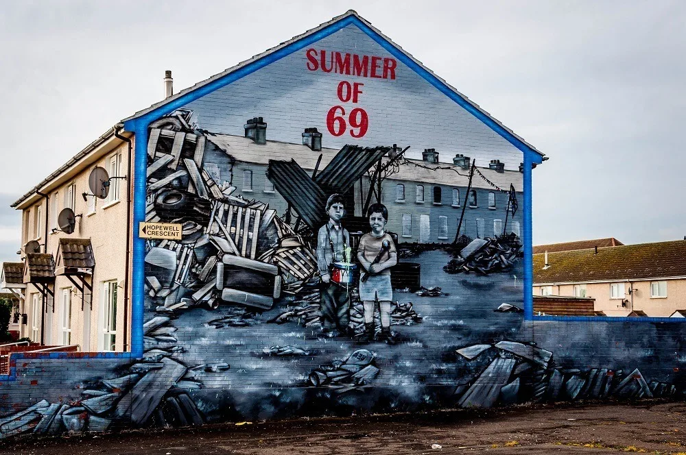 Street art mural with the label "Summer of 69" showing young boys among ruins
