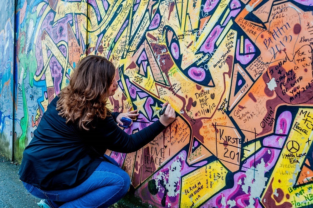 Laura signing the Peace Wall