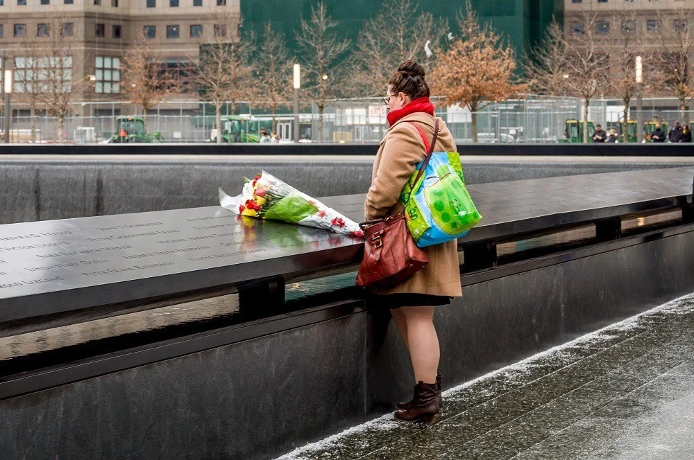 Visitor with a bouquet of flowers at the September 11 Memorial