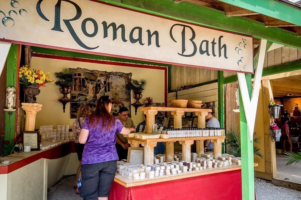 Person shopping for soap under a sign for "Roman Bath"