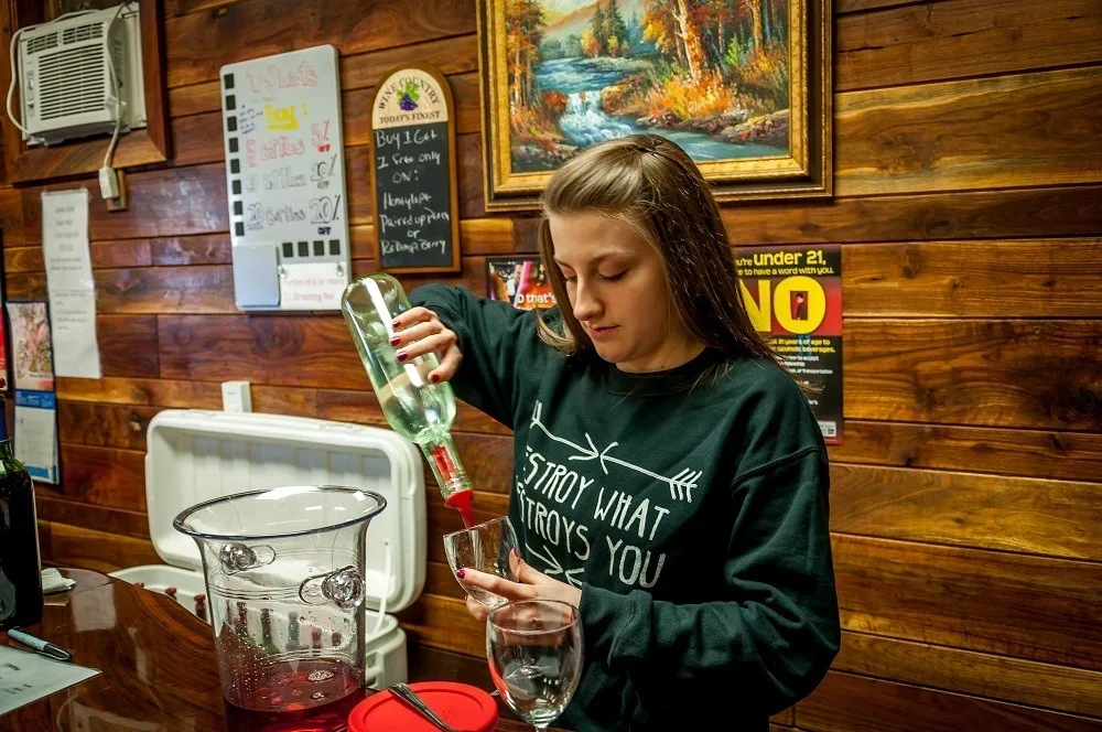 Woman pouring a wine tasting at Buddy Boy, one of the most unusual wineries in Pennsylvania