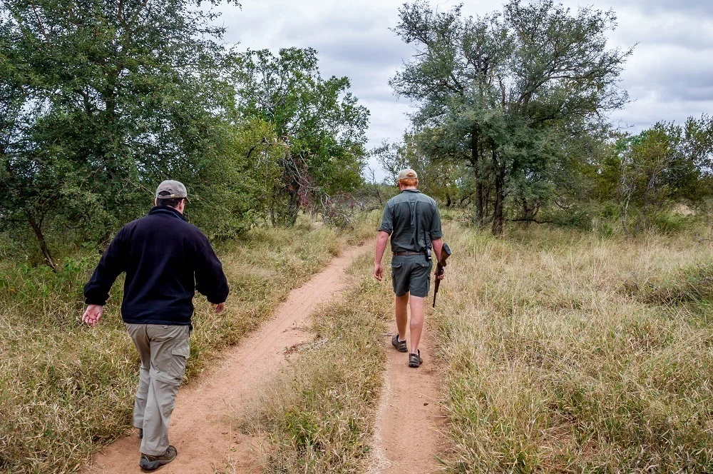 Lance walking with guide at Africa on Foot safari camp