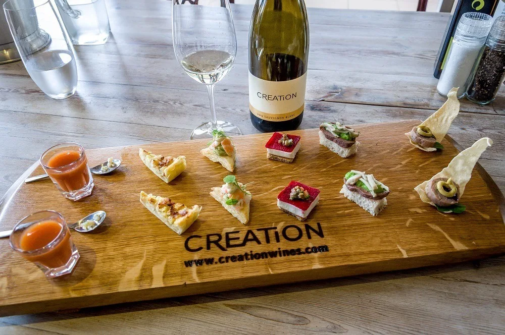 The canapés tasting board at Creation Wines with bottle and glass of wine