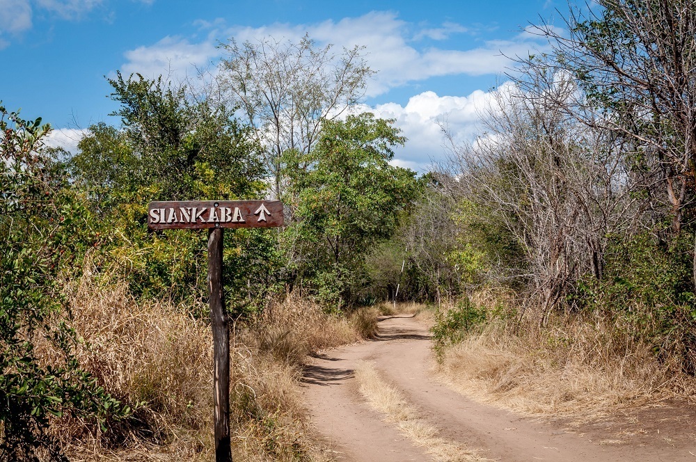 Sign on dirt road point to Siankaba