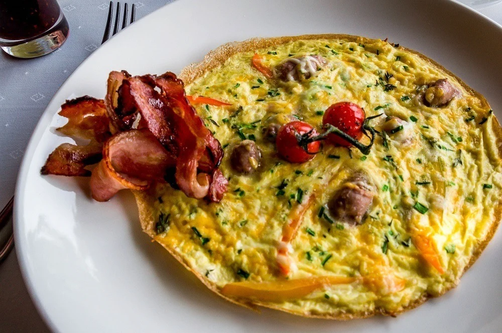 Breakfast omelet with bacon on plate