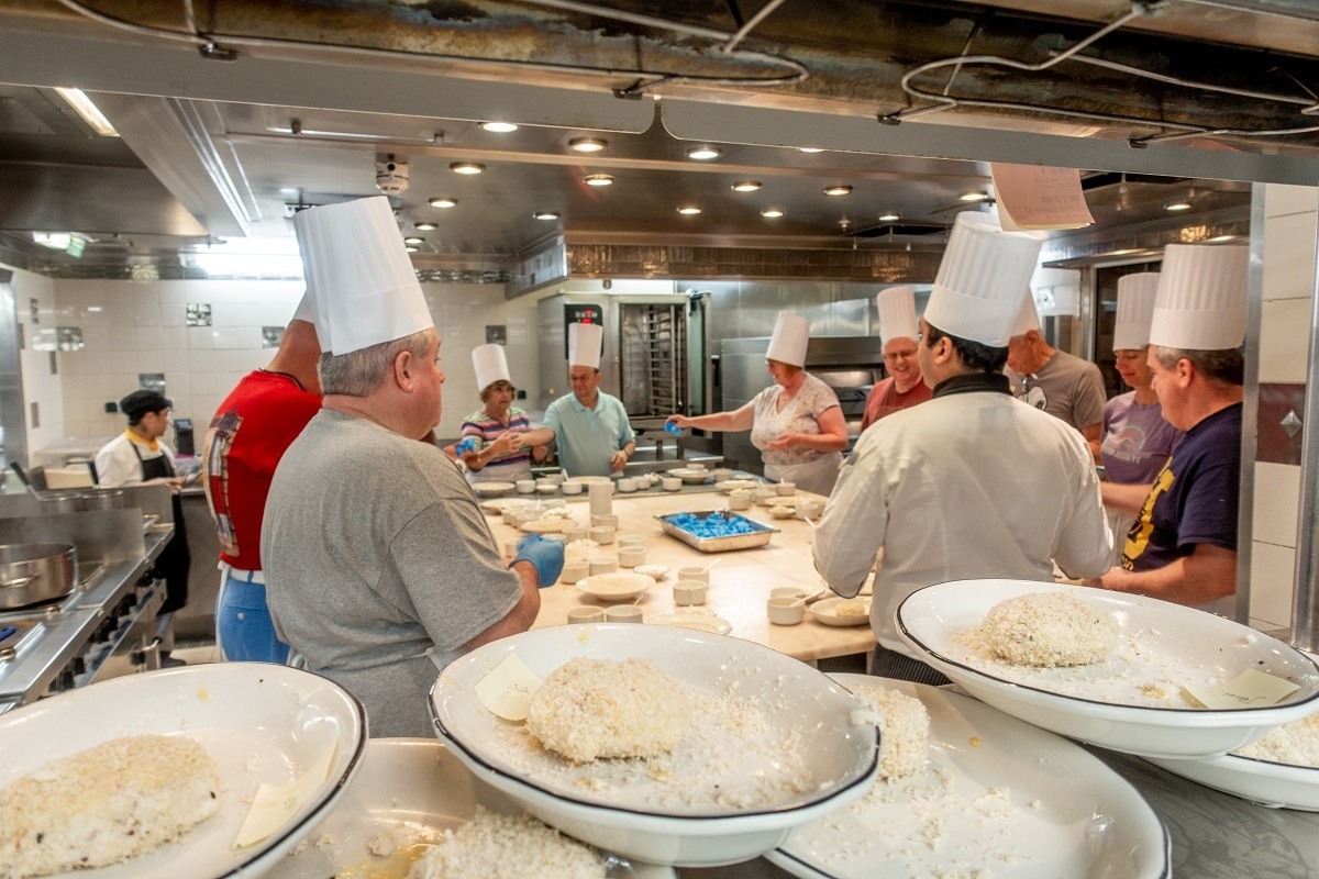 People wearing chefs hats in a cooking class 
