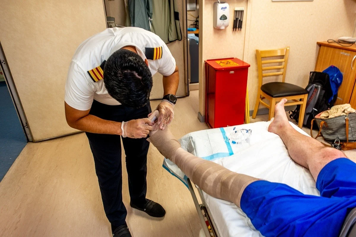 Ship's doctor working on a patient's foot