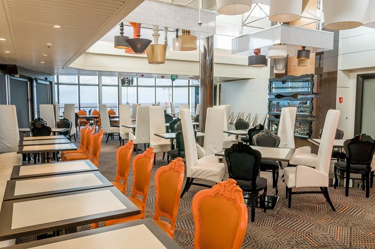 Orange, white, and black chairs at tables in an empty restaurant