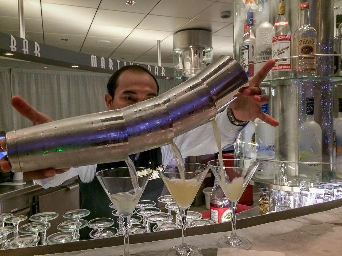 Bartender pouring three martinis at once