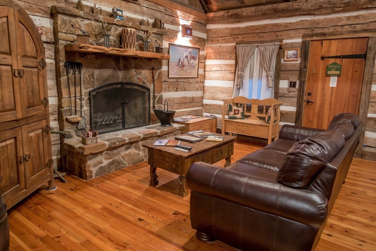 Living room of cabin with couch and fireplace at Cotton Gin Village