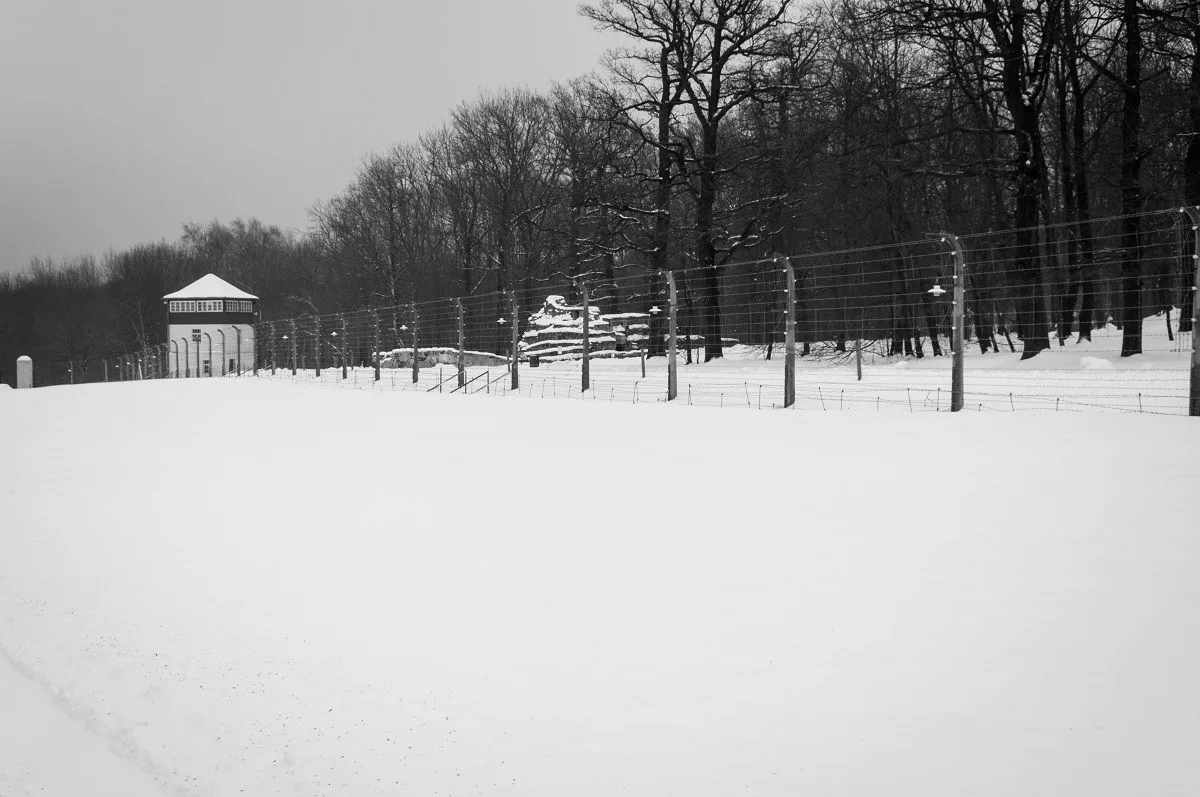 A Nazi concentration camp guard tower and fence in the snow