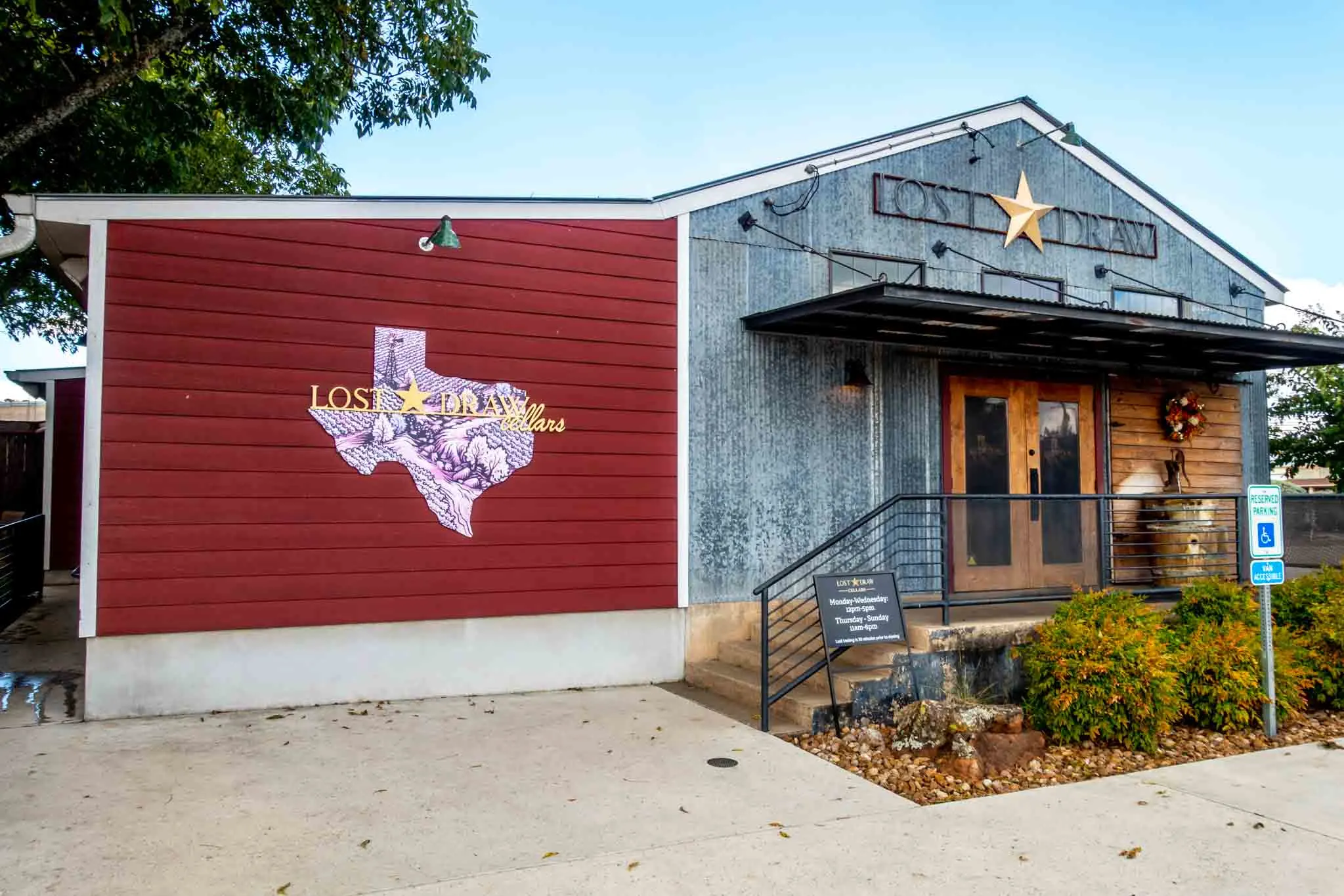 Exterior of Lost Draw tasting room with Texas-shaped logo and signs