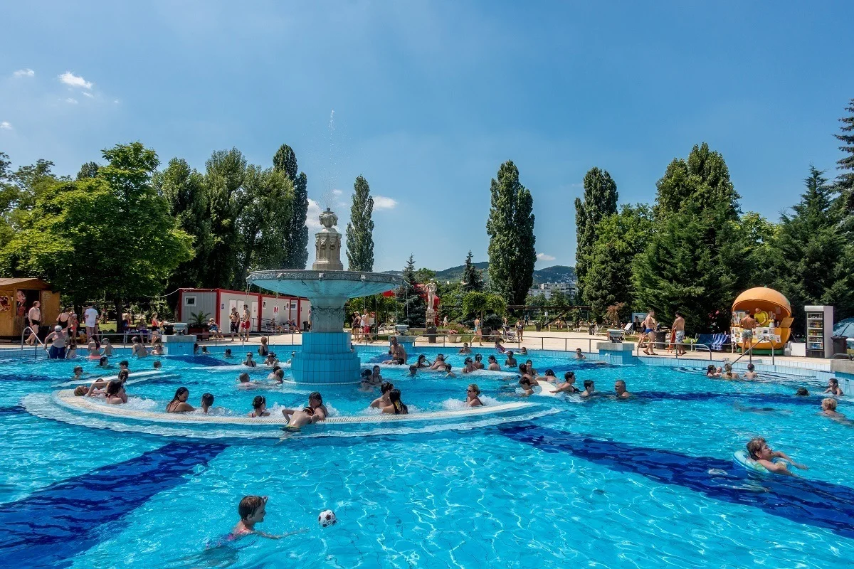 People in a pool with a fountain in the center