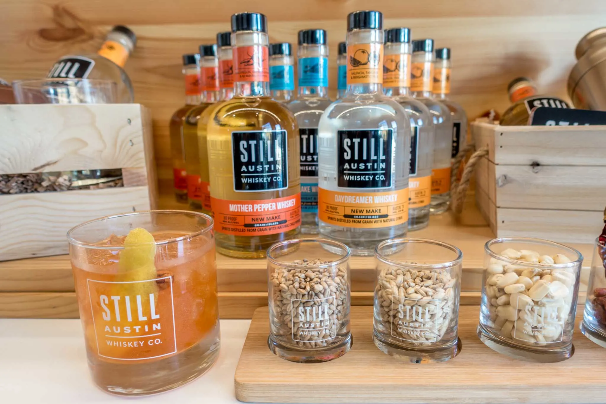 Bottles and cocktail glass labeled as Still Austin Whiskey Co.