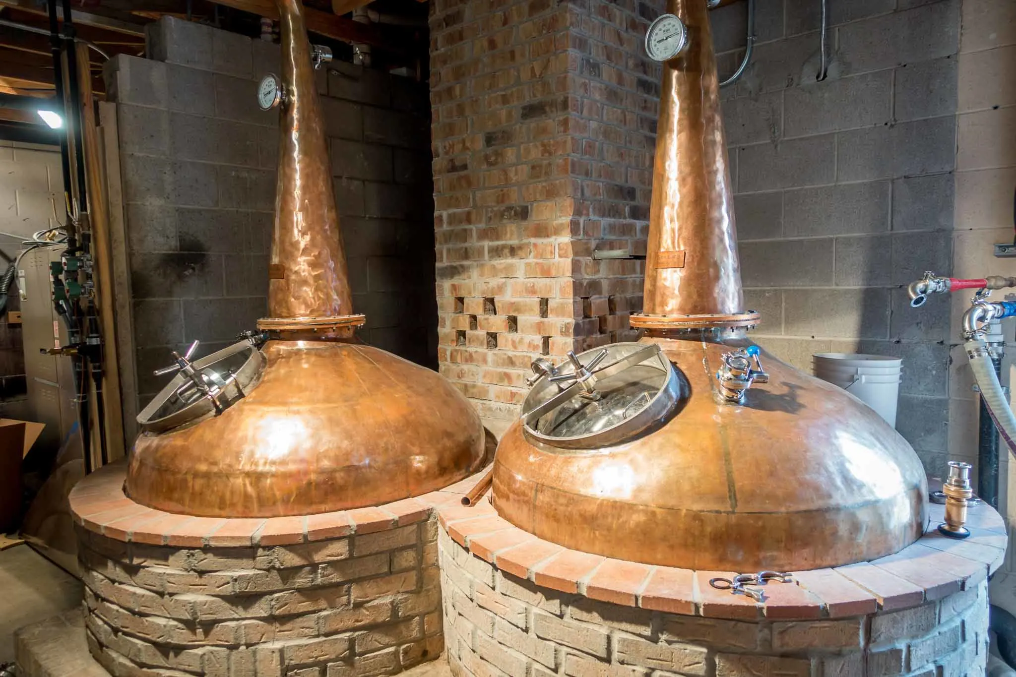 Copper stills surrounded by brick