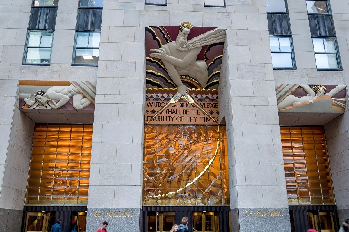 Gold, red, and white Art Deco relief Wisdom above door at Rockefeller Center