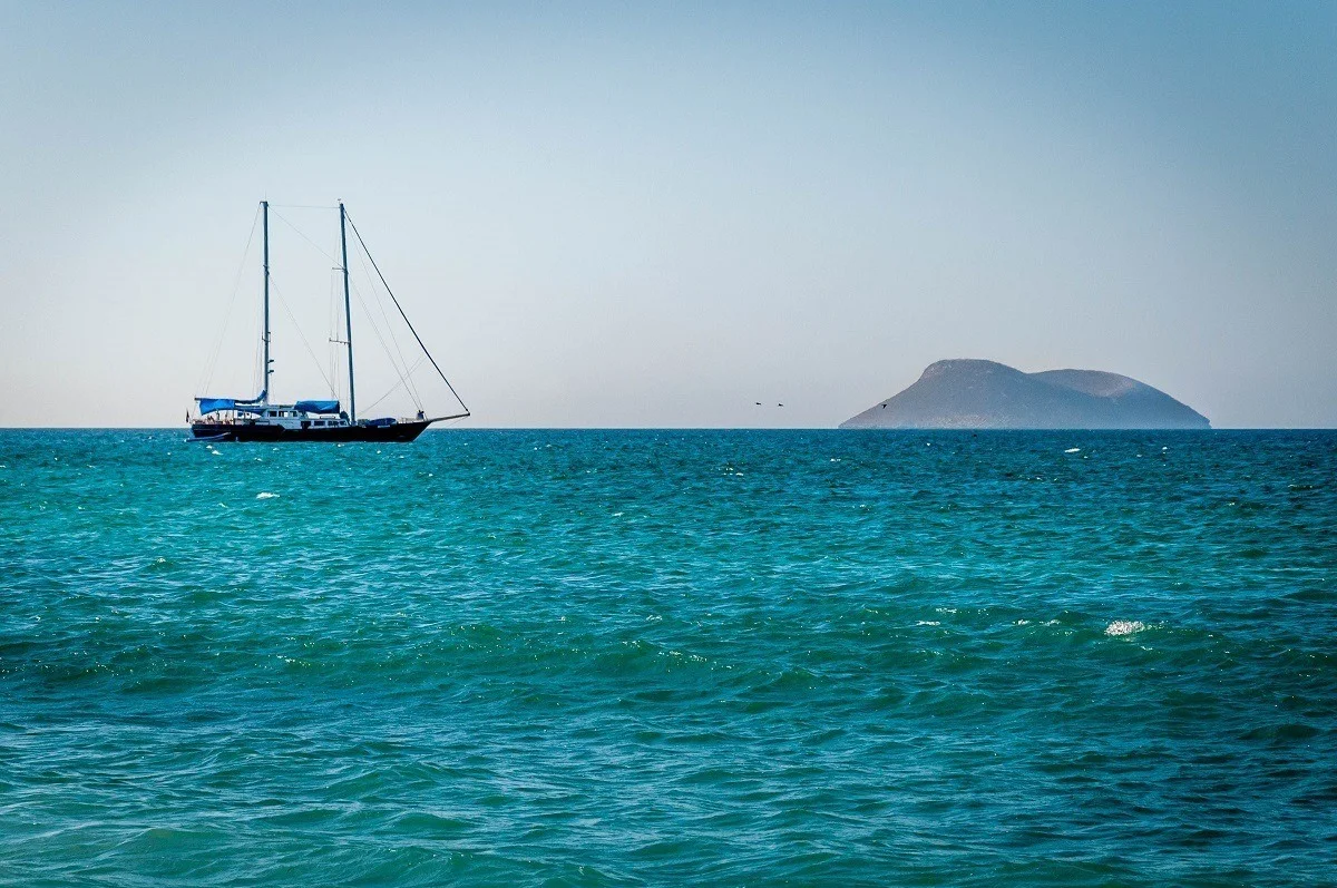 A sailboat on the ocean near an island
