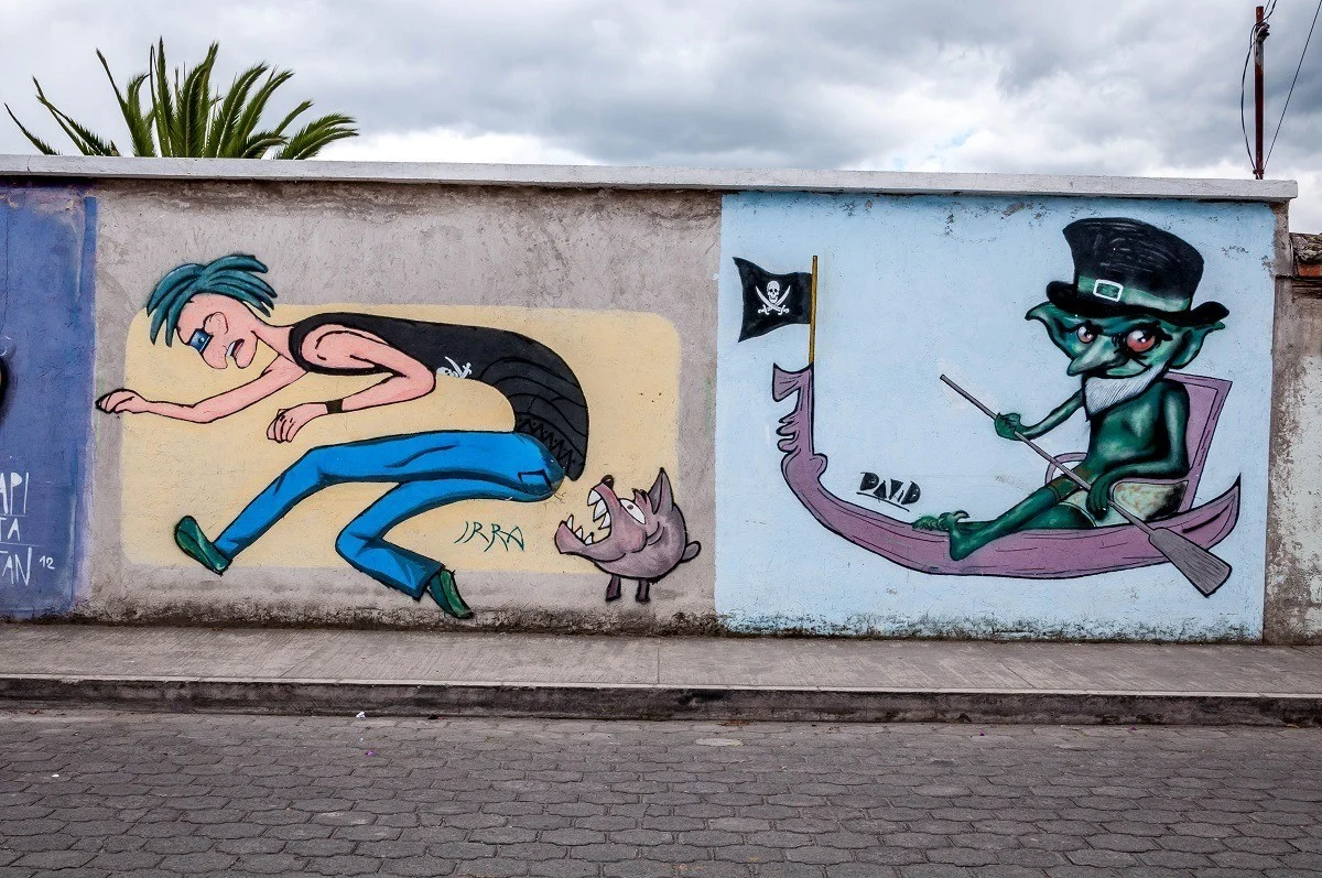 Otavalo street art murals of dog biting boy and pirate in canoe