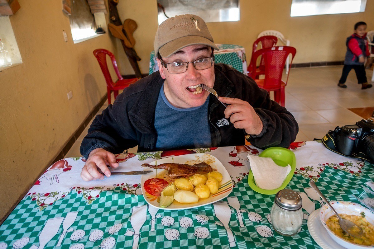 Man eating cuy (guinea pig), a popular Ecuadorian food