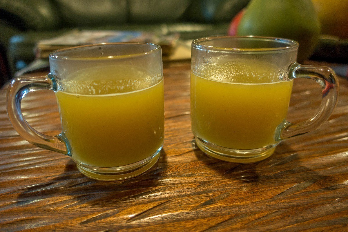 Hot yellow drink in two mugs.