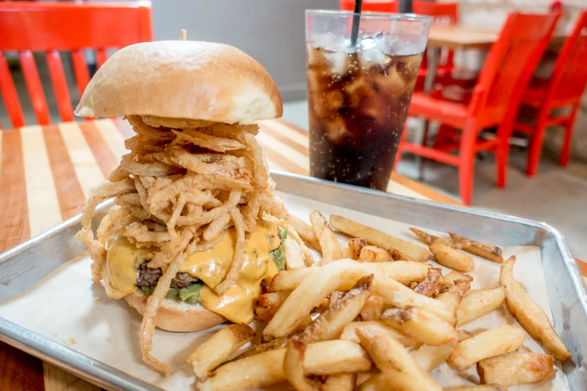 French fries beside a hamburger piled high with fried onions