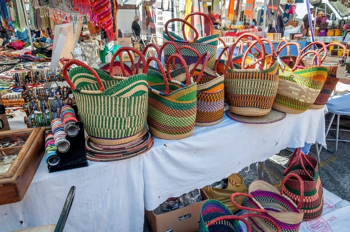 Multi-colored baskets displayed for sale at an outdoor market 